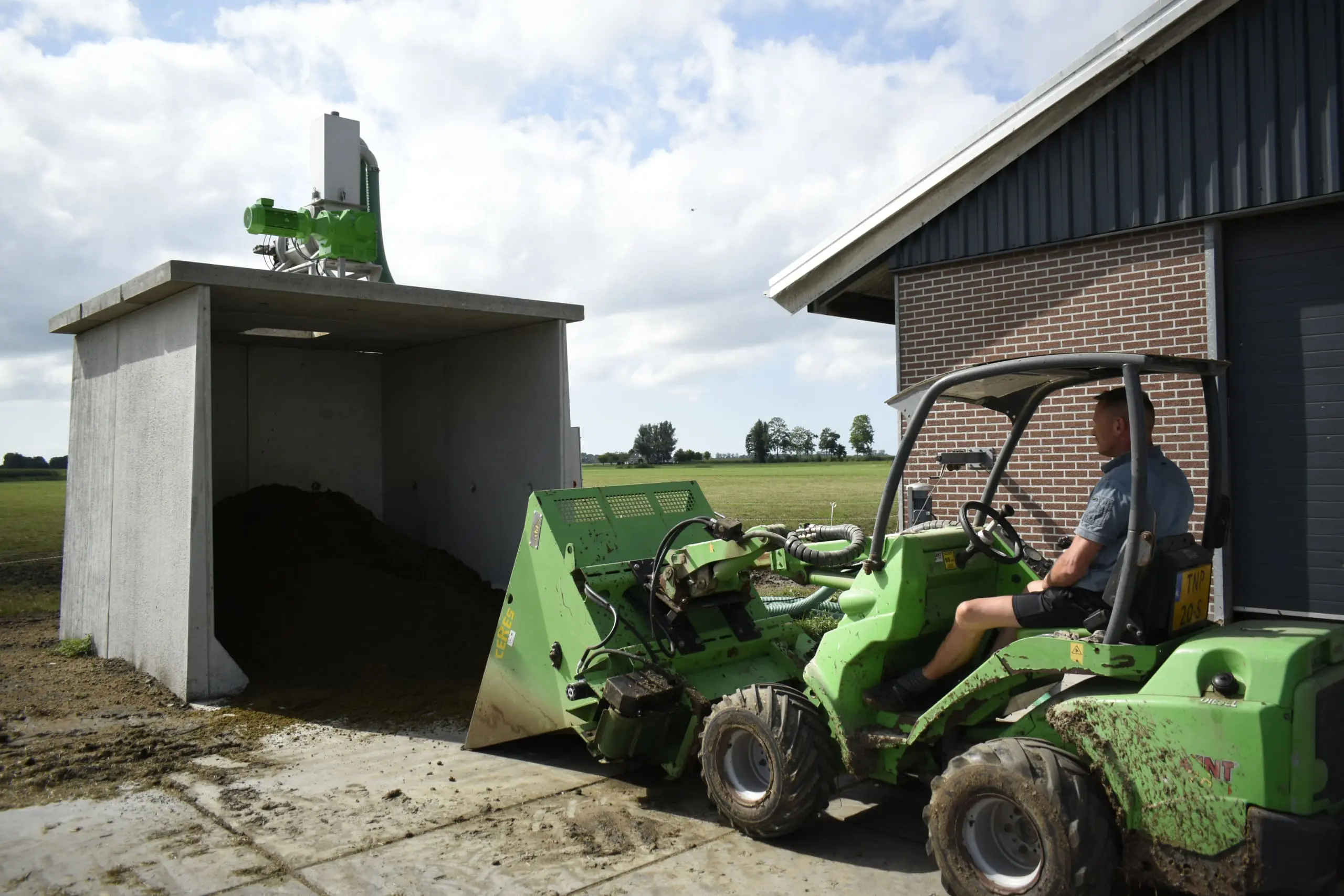 Boer Henk-Jan pakt zijn verse vracht biobedding uit de bunker om in te strooien