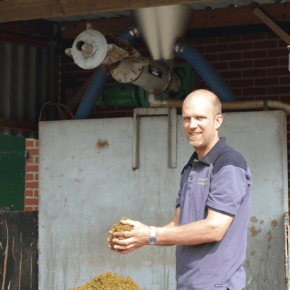 Melkveehouder Leon Schukkink uit Twekkelo met dikke fractie in zijn hand uit de mestscheider